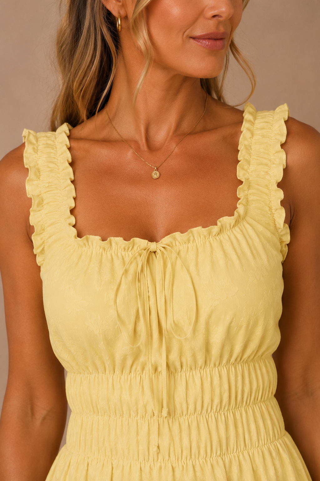 Detalle del escote cuadrado y los tirantes fruncidos del Vestido Cashia Palermo amarillo. Primer plano mostrando el acabado del tejido y el lazo frontal.