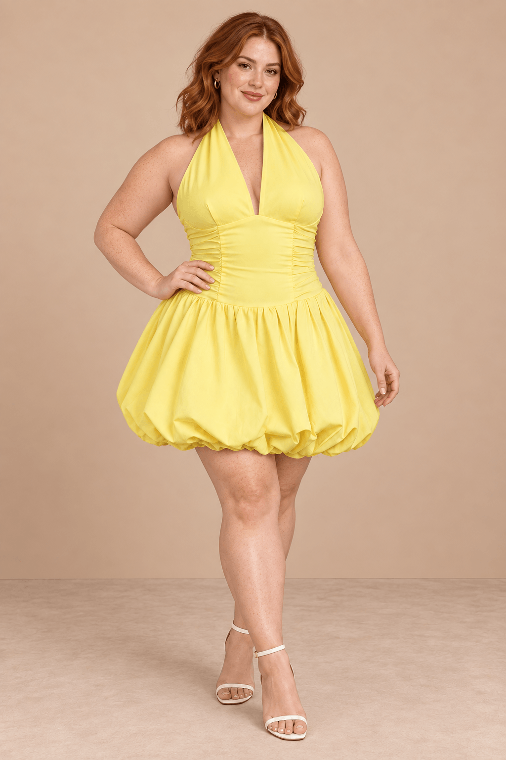 Modelo Cashia talla XL con Vestido Cashia Sorrento amarillo, escote halter y falda globo, en pose dinámica sobre fondo nude.
