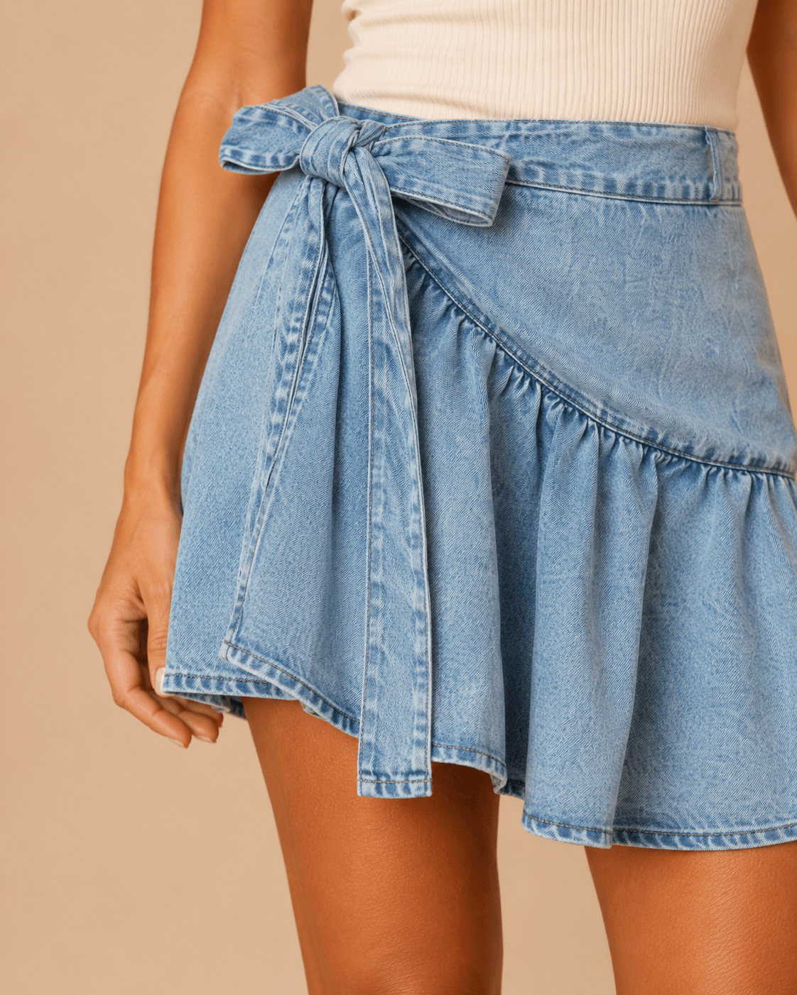 Detalle del lazo lateral de la Falda Cashia Denim Lazo azul con tejido denim y volante inferior.