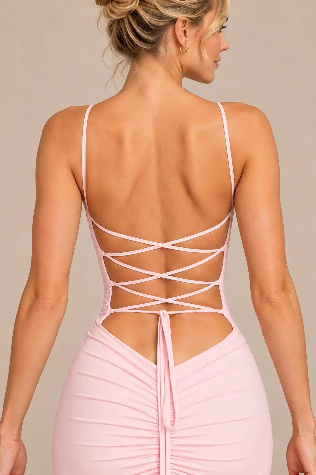Detalle de la espalda del vestido Cashia Ravello rosa, con cordones cruzados y tejido fruncido.