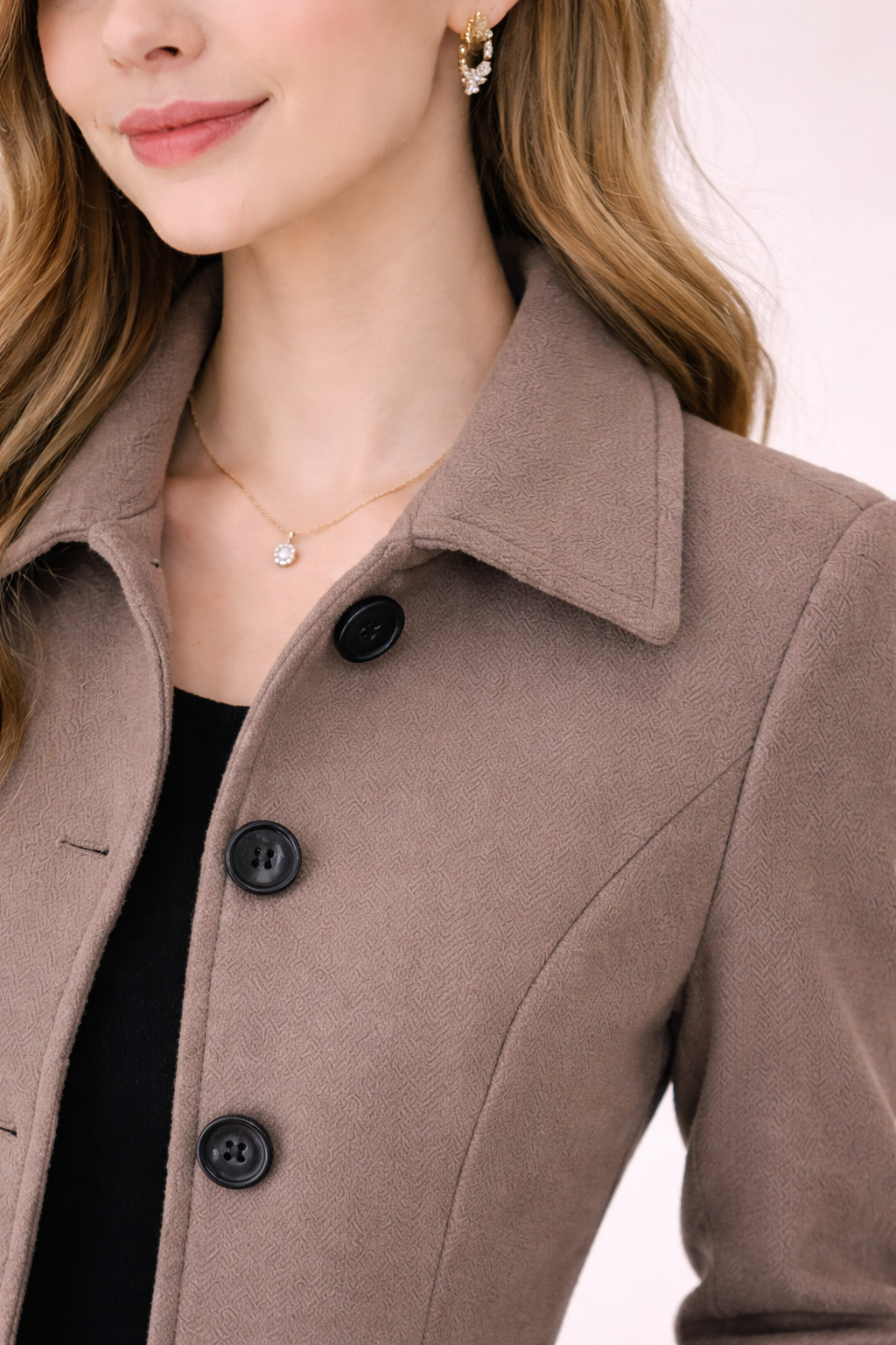 Detalle de cuello y botones del abrigo Cashia Berlín color coffee brown de algodón, tejido texturizado y corte entallado, fondo nude con estilo elegante y premium.