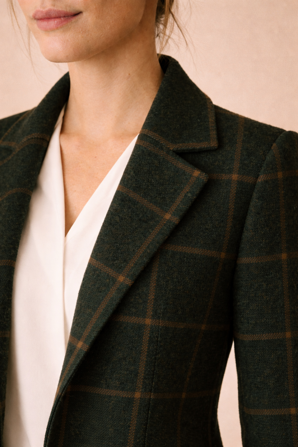 Detalle de cuello y solapa del abrigo Cashia Copenhague verde oscuro de cuadros, mostrado abierto y sin botones visibles, destacando el tejido y acabado sobre fondo nude.