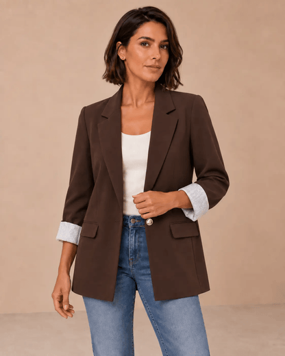 Blazer Cashia Celaje marrón chocolate con botón dorado en modelo de pelo corto talla M, vista frontal en medio plano superior.