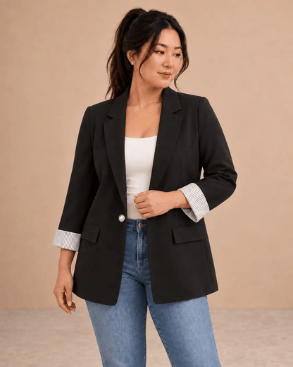 Blazer Cashia Celaje negro con botón dorado en modelo talla L, vista frontal en medio plano superior.