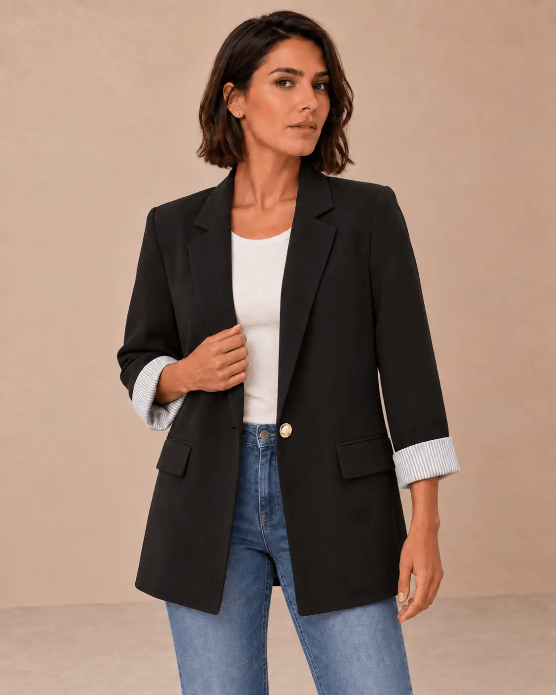 Blazer Cashia Celaje negro con botón dorado en modelo de pelo corto talla M, vista frontal en medio plano superior.