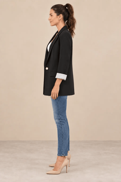 Blazer Cashia Celaje negro con botón dorado en modelo talla S, vista de perfil.