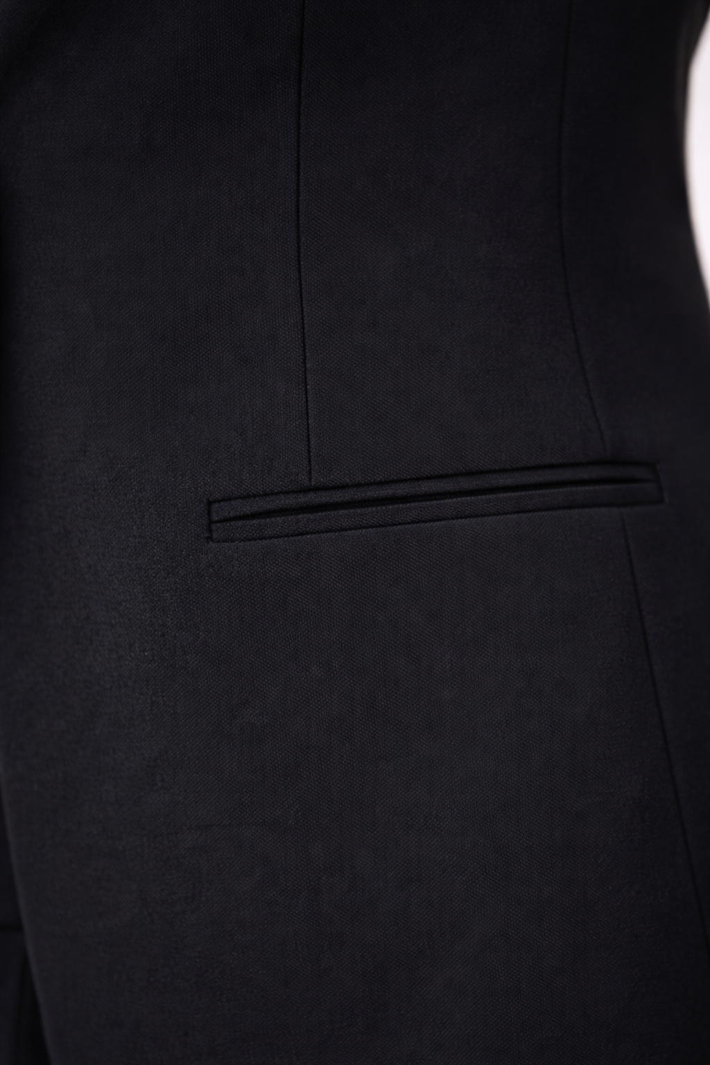 Detalle del bolsillo vivo horizontal sin solapa del blazer Cashia Helena en color negro con tejido liso estructurado.