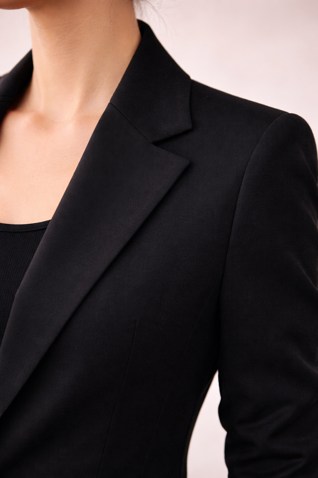 Detalle del cuello y solapa estructurada del blazer Cashia Helena en color negro con tejido liso y acabado entallado.