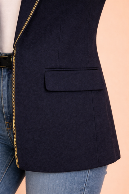 Detalle de la solapa del Blazer Cashia Sofía azul marino con ribete dorado en el borde, mostrando el acabado elegante sobre fondo nude.