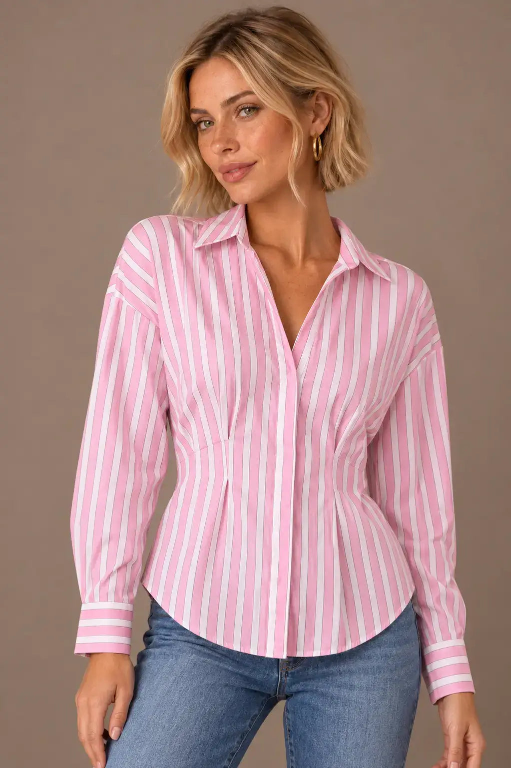 Modelo Cashia rubia de melena corta y pecas con Camisa Cashia Clara de rayas rosas y blancas en talla XS, en medio plano superior con vaqueros.