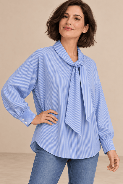 Camisa Cashia Elisa azul en talla M, sobre modelo morena con corte bob y una mano en la cadera, en medio plano superior.