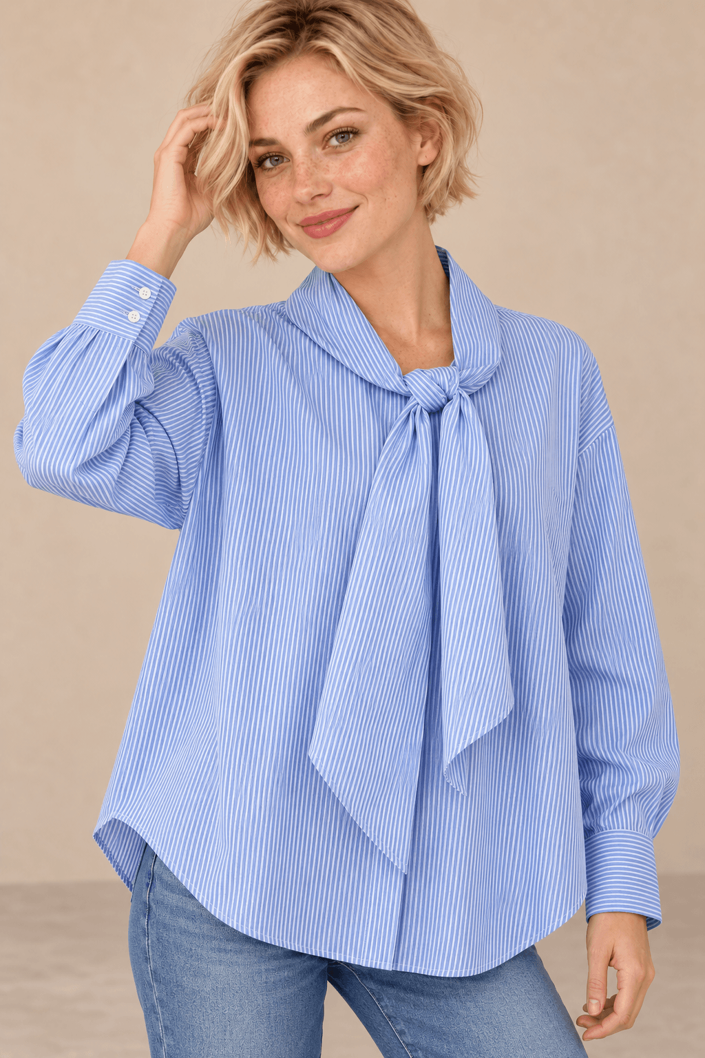 Camisa Cashia Elisa azul en talla XS, sobre modelo rubia de pelo corto y pecas, con una mano junto al cabello.
