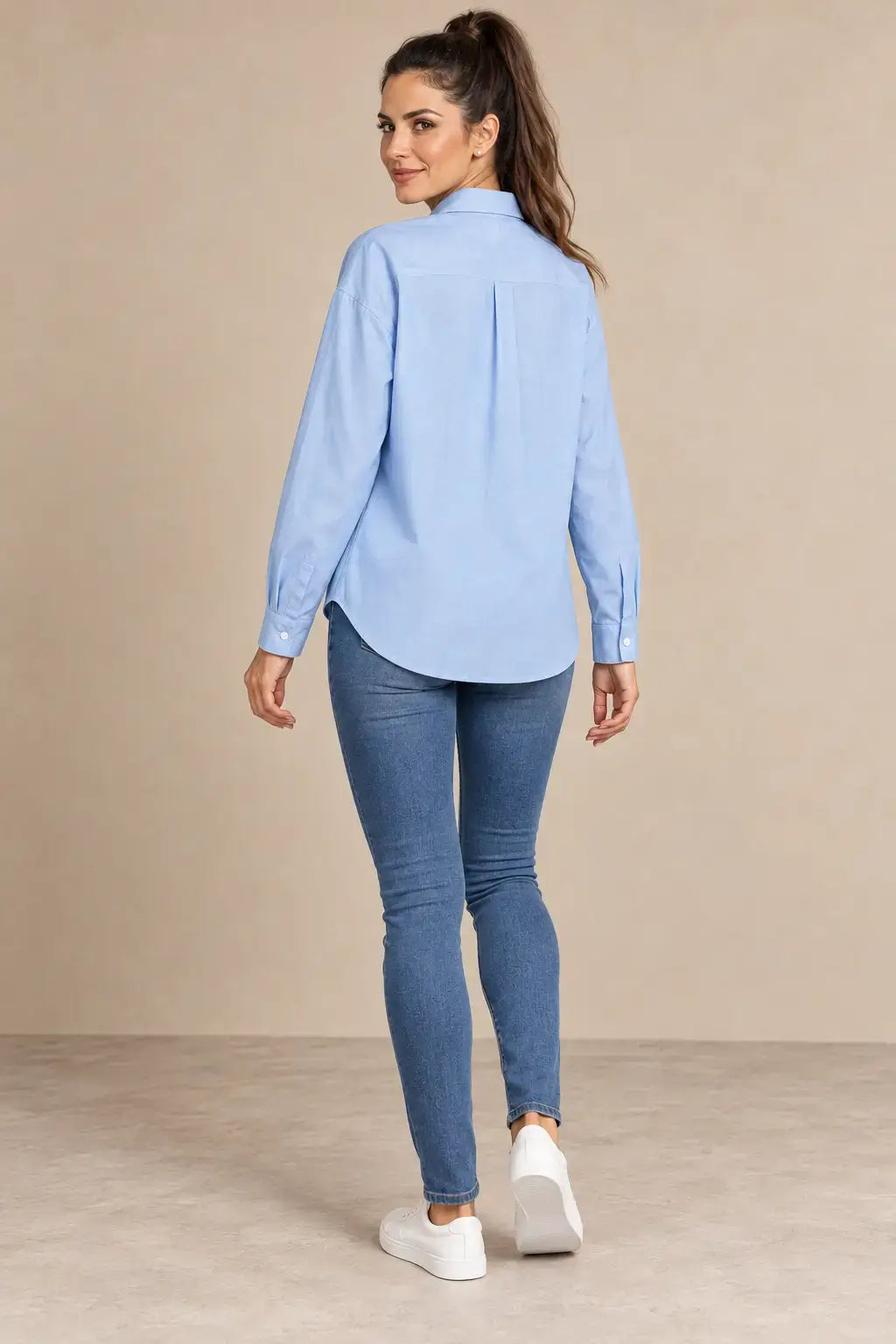Espalda de la Camisa Cashia Irene azul claro, con canesú y pliegue central, en modelo morena.