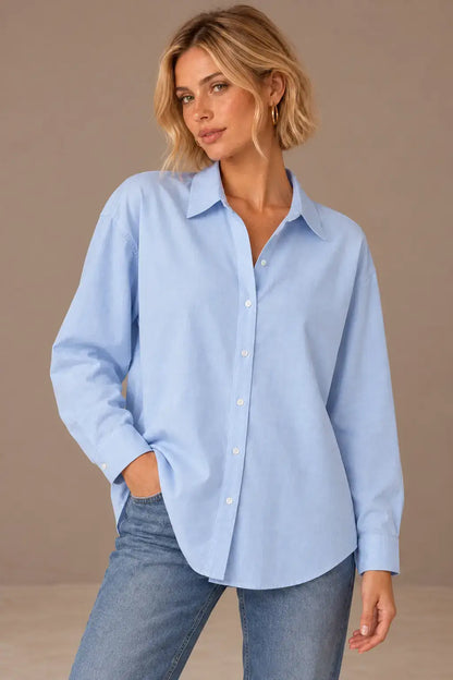 Camisa Cashia Irene azul claro, talla XS, en modelo rubia de melena corta, con puños cerrados y vaqueros.