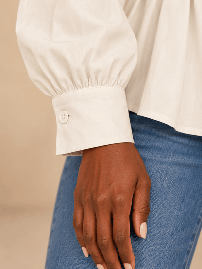 Primer plano del puño ancho de la camisa Cashia Vera cruda, con un botón a tono y manga fruncida.