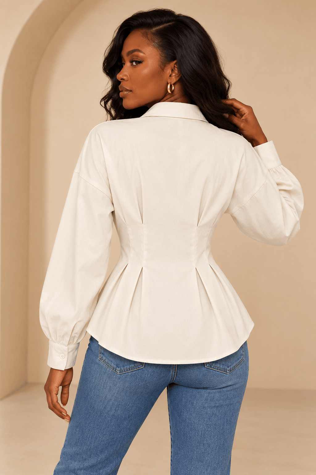 Espalda de la camisa Cashia Vera cruda, con pinzas y pliegues en la cintura, sobre modelo Cashia negra con tejanos.