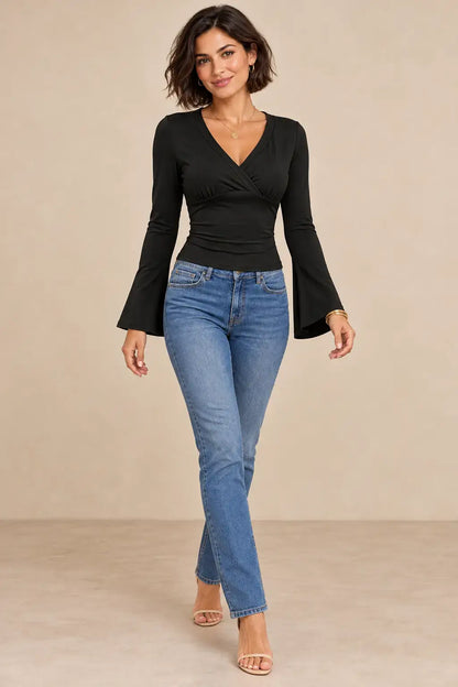 Modelo usando camiseta escote cruzado mangas acampanadas con jeans, para un look elegante y moderno.