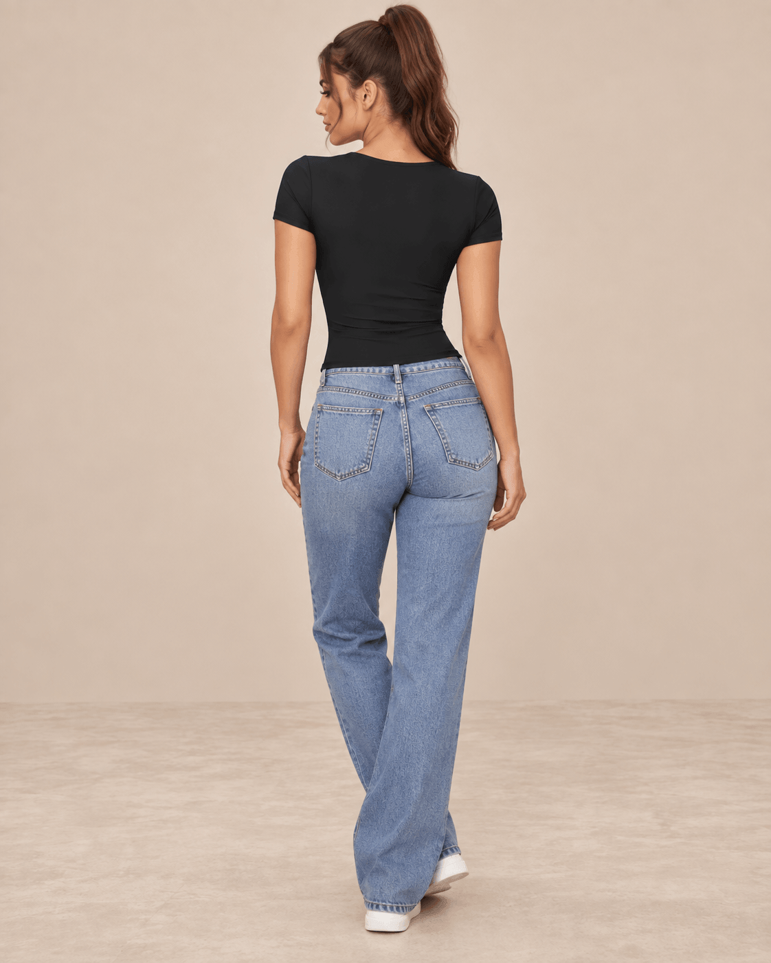 Camiseta Cashia Basic MCV negra en modelo morena con cola alta, vista de espalda con vaqueros