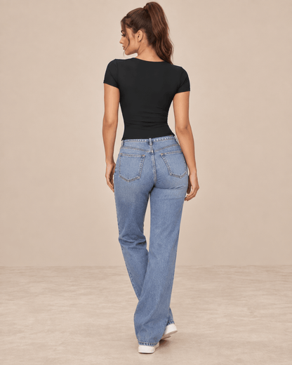 Camiseta Cashia Basic MCV negra en modelo morena con cola alta, vista de espalda con vaqueros