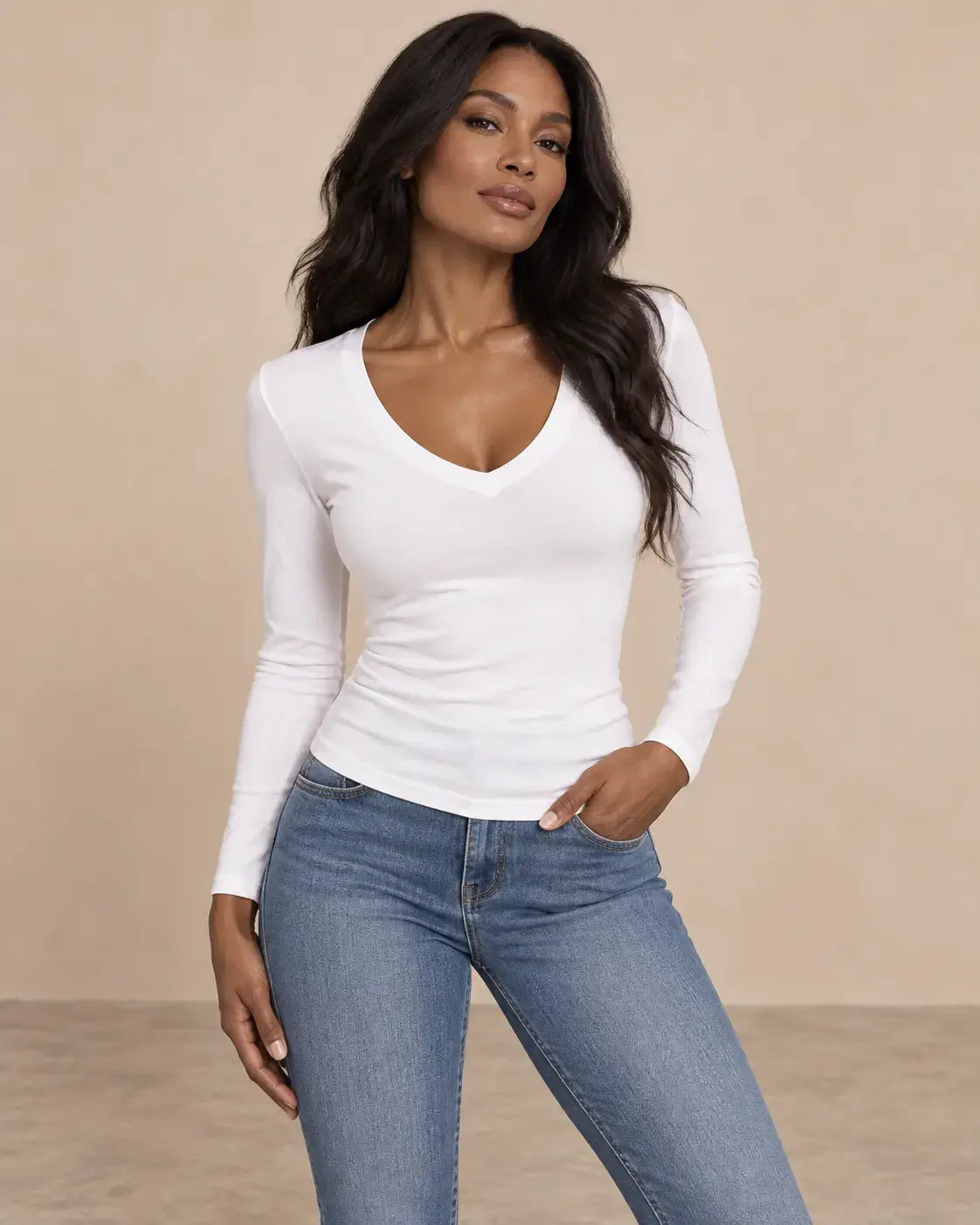 Camiseta Cashia Basic MLV blanca con escote en V y manga larga, combinada con vaqueros, modelo Cashia de raza negra para talla S, en medio plano superior y pose dinámica.
