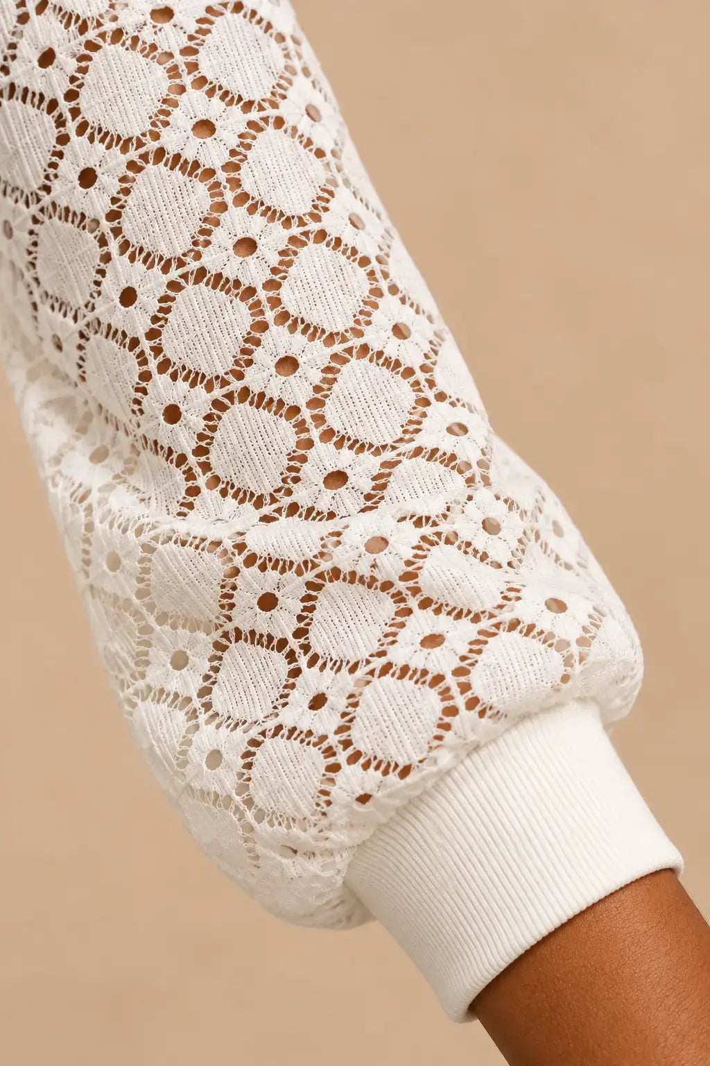 Detalle de la camiseta mujer mangas caladas cuello redondo, con mangas largas de diseño geométrico en color blanco.
