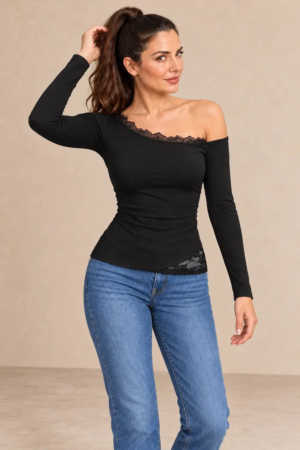 Camiseta negra manga larga encaje asimétrico en modelo con jeans, mostrando estilo elegante y moderno.