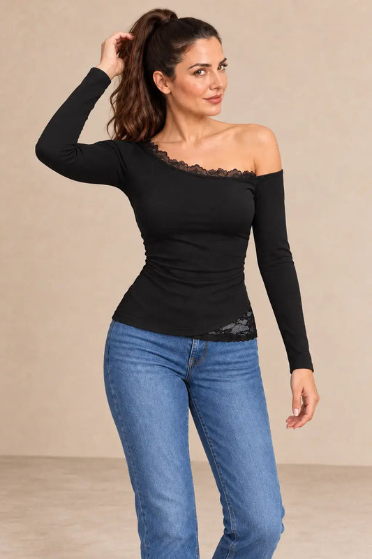 Camiseta negra manga larga encaje asimétrico en modelo con jeans, mostrando estilo elegante y moderno.