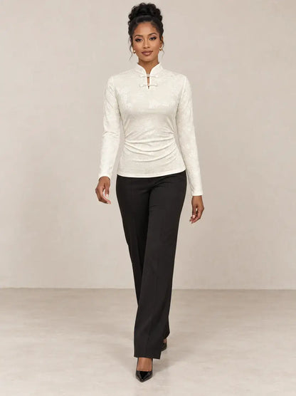 Camiseta mujer cuello mao detalle floral Cashia Nácar, estilo elegante con pantalones negros.