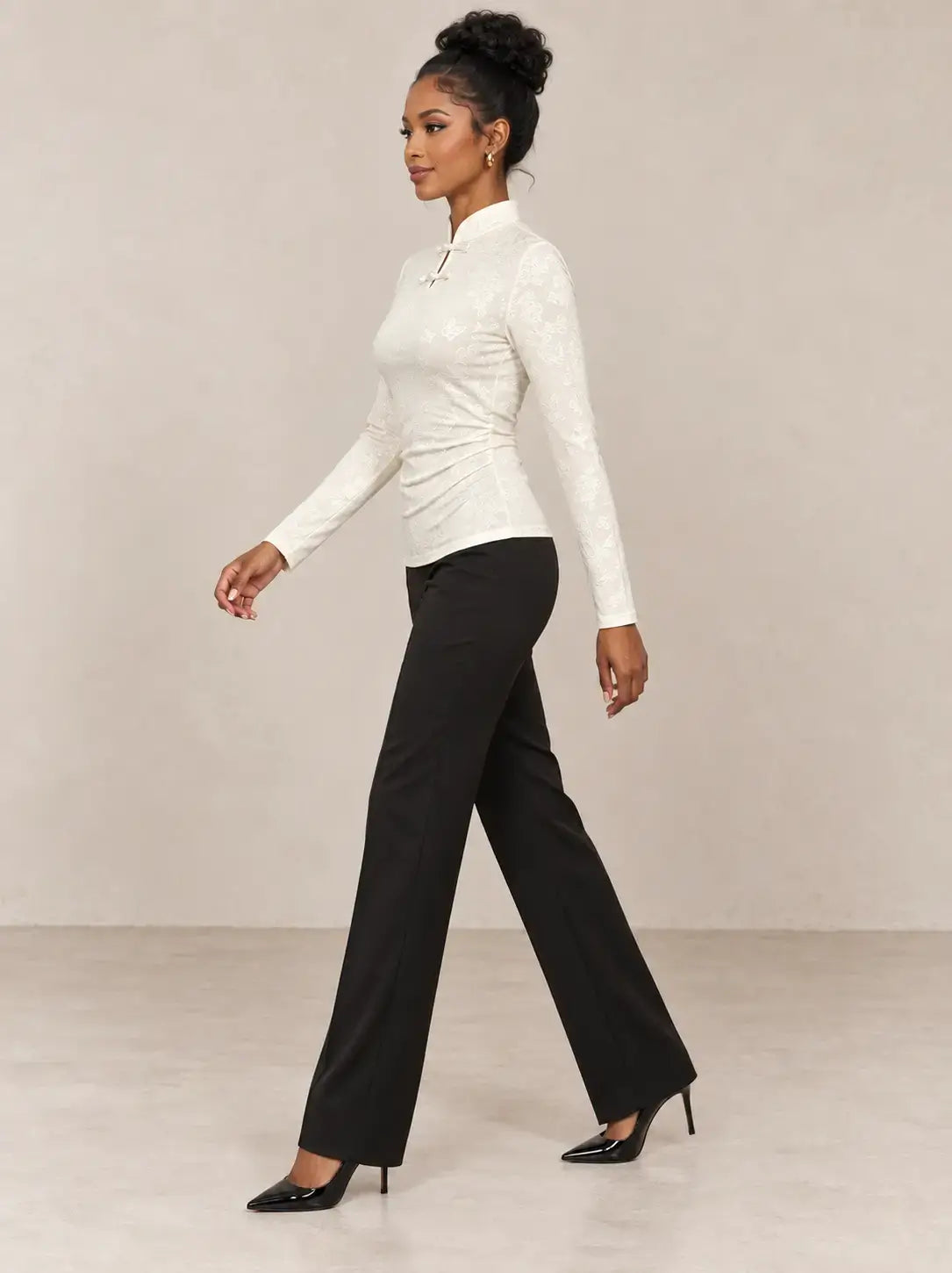 Camiseta mujer cuello mao detalle floral Cashia Nácar en color blanco, combinada con pantalones negros elegantes.