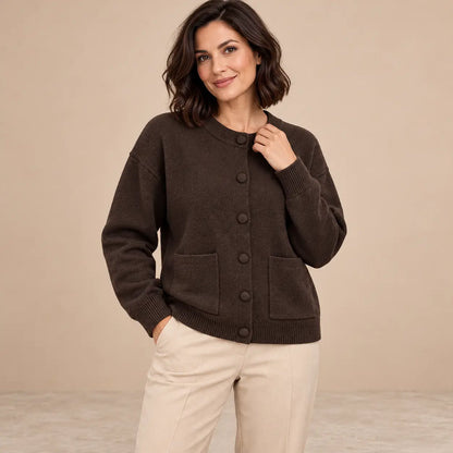 Cárdigan Cashia Tejo marrón oscuro, talla M, sobre modelo de pelo bob con pantalón beige.