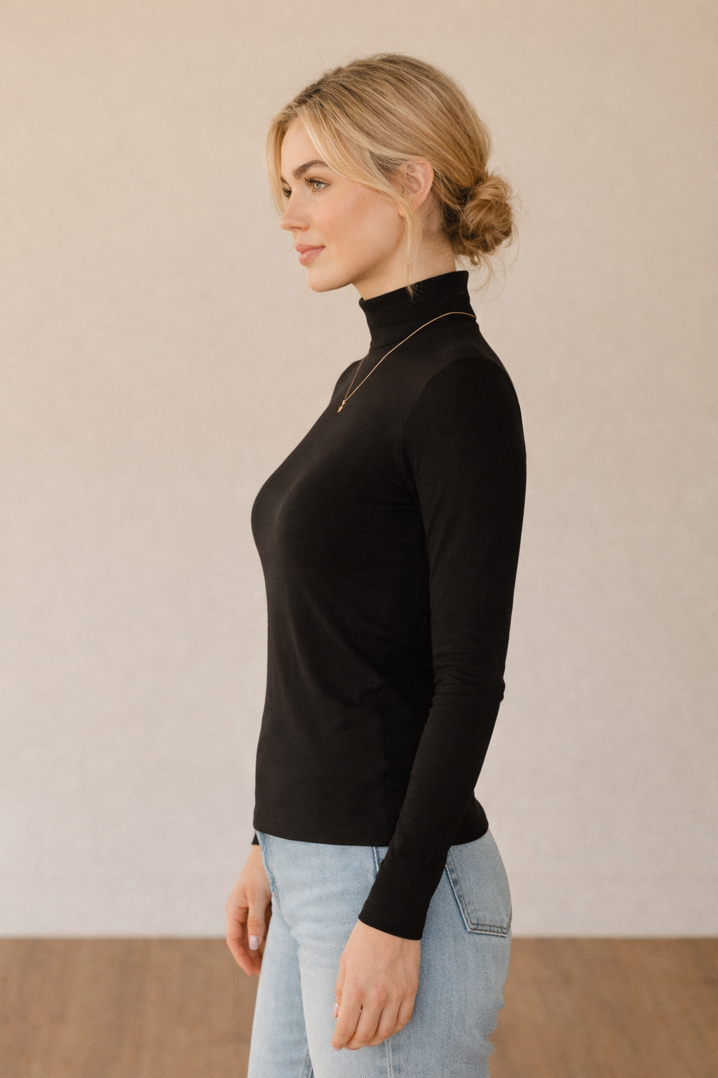 Camiseta negra Cashia Basic CA de manga larga, vista de perfil, mostrando el ajuste lateral y la caída de la prenda sobre el cuerpo.