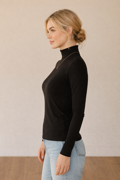 Camiseta negra Cashia Basic CA de manga larga, vista de perfil, mostrando el ajuste lateral y la caída de la prenda sobre el cuerpo.