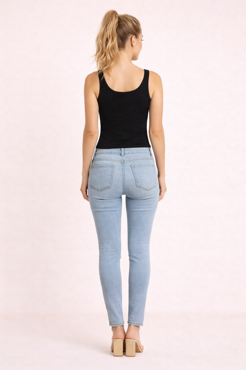 Top Cashia Basic negro en modelo rubia elegante vista trasera, espalda y ajuste del top con jeans claros