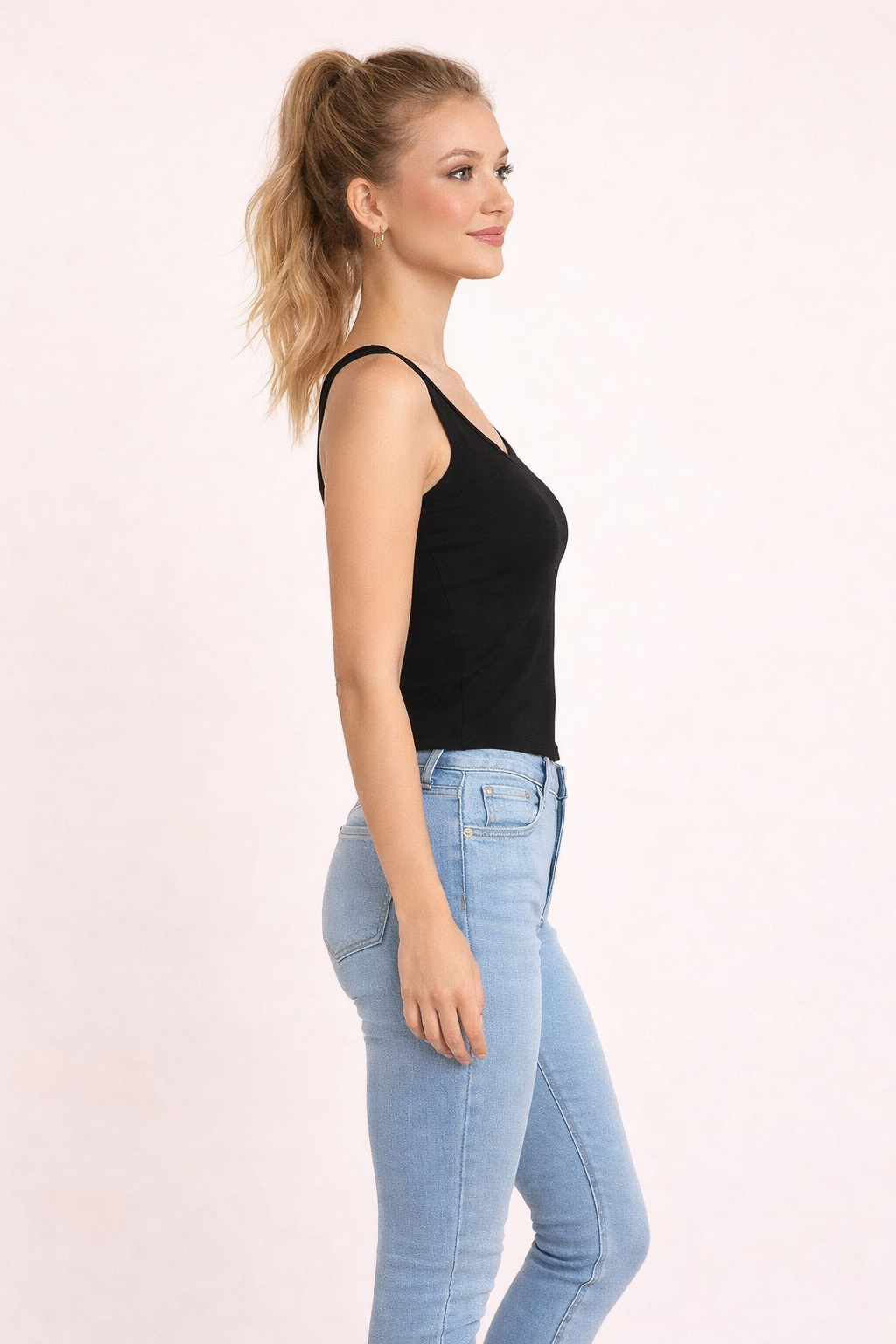 Top Cashia Basic negro en modelo rubia elegante vista lateral, perfil mostrando ajuste del tejido y silueta