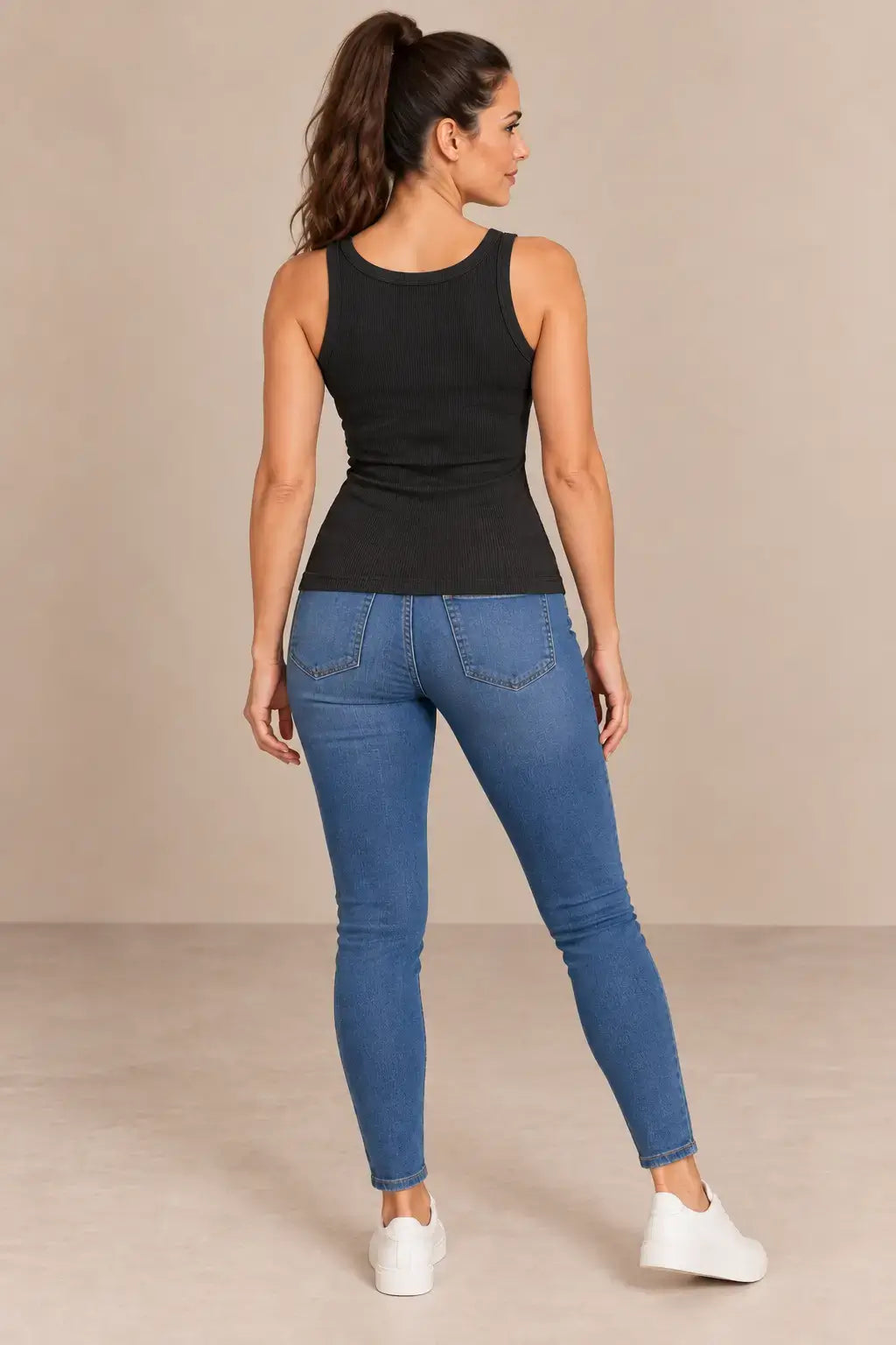 Vista de espalda de la camiseta Cashia Basic TAU negra con modelo talla S y vaqueros.