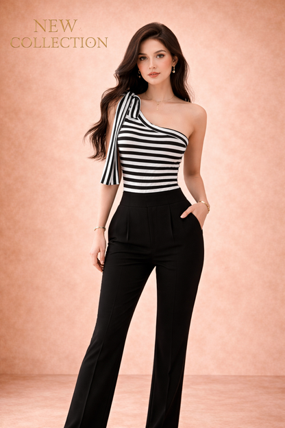 Top Cashia Cannes de rayas blanco y negro con tirante asimétrico y lazo, combinado con pantalón negro, vista frontal cuerpo entero