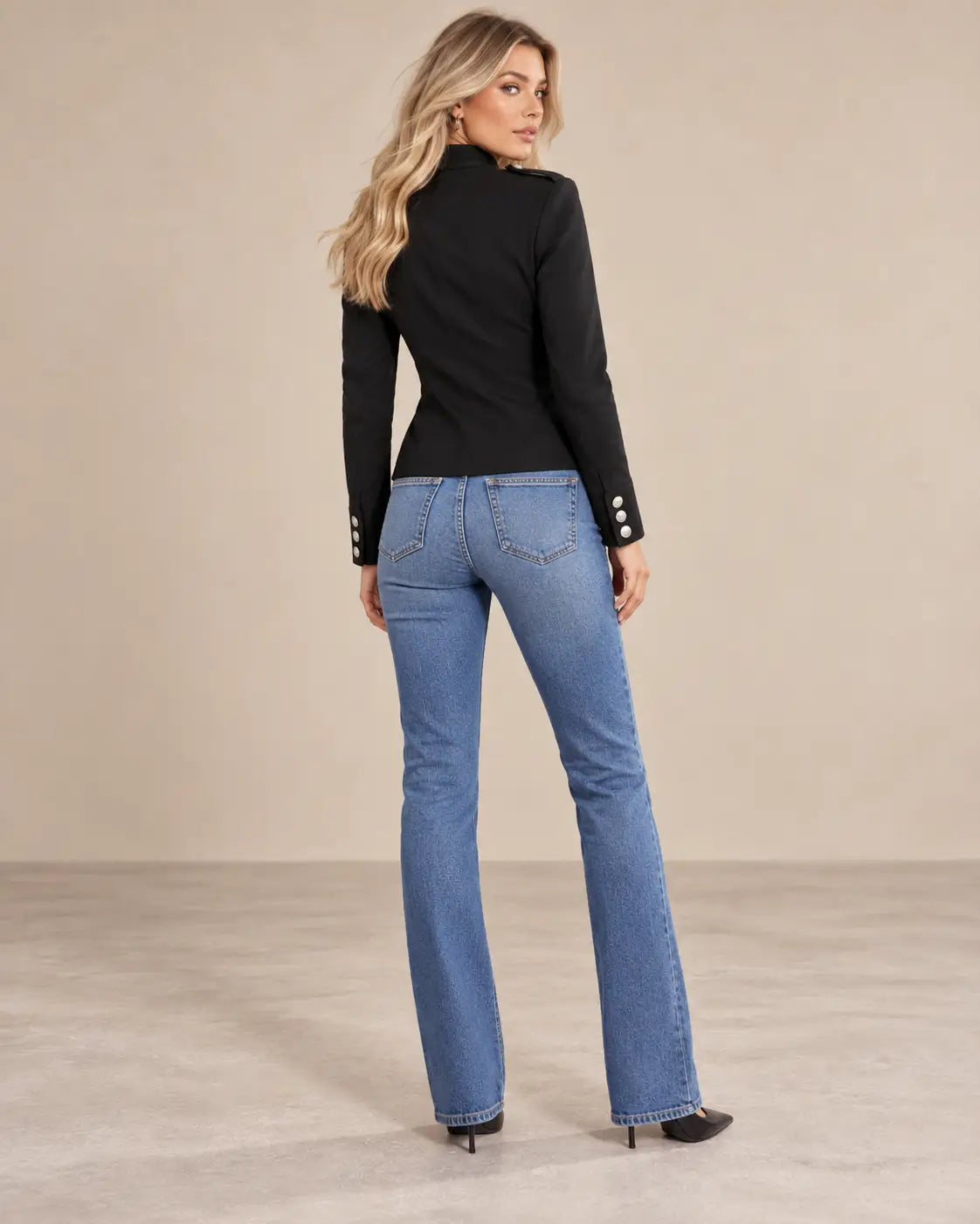 Chaqueta Cashia Céfiro negra, vista trasera, sobre modelo rubia talla S con pantalón vaquero y manga larga.