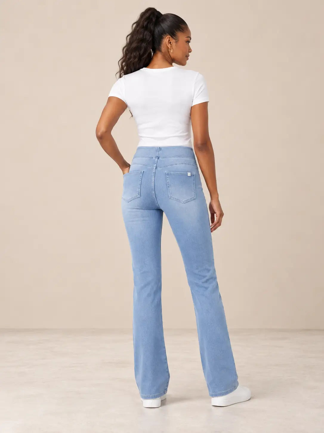Pantalón Cashia Denim 200 en azul claro, modelo con camiseta blanca y zapatillas blancas, vista espalda