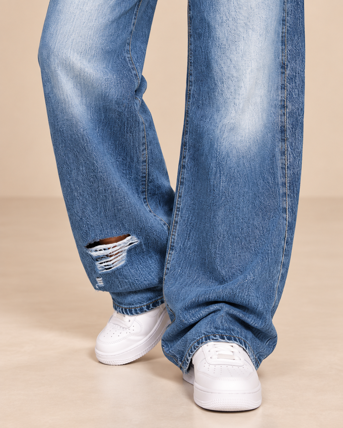 Detalle del bajo roto del pantalón Cashia Denim 303 en azul denim claro.