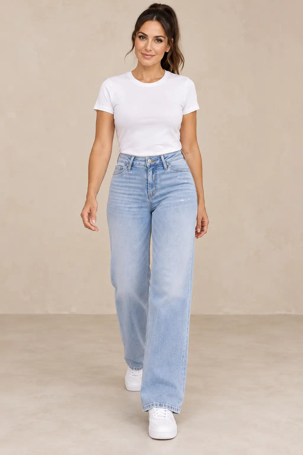 Pantalón Cashia Denim 402 azul claro, vista frontal con modelo morena, camiseta blanca y zapatillas blancas.