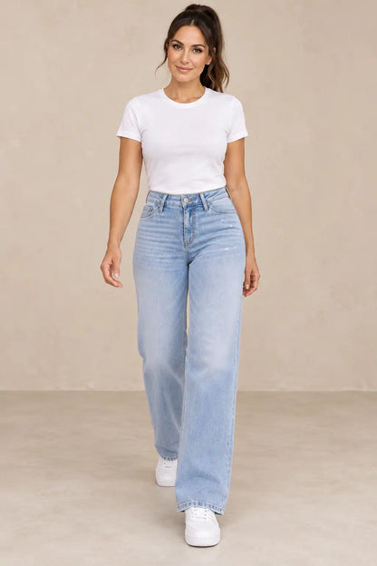 Pantalón Cashia Denim 402 azul claro, vista frontal con modelo morena, camiseta blanca y zapatillas blancas.