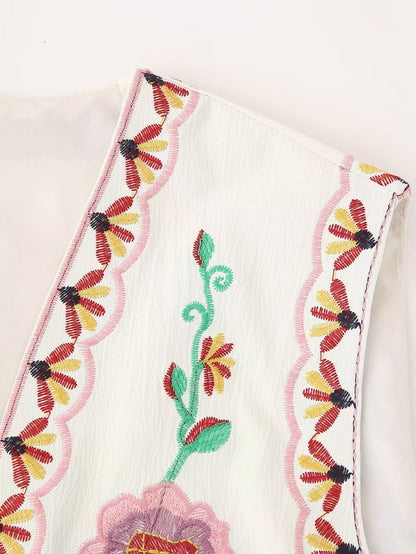 Detalle del bordado floral y acabado curvado de la sisa del Chaleco Cashia Nice en tono crema con motivos bordados en rosa, verde y amarillo