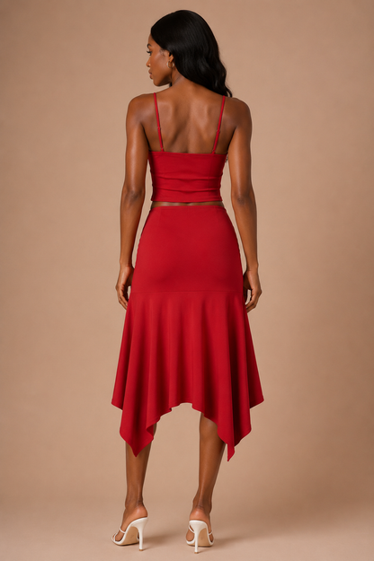 Vista trasera del Conjunto Cashia Elba rojo en modelo de raza negra, con top de tirantes y falda midi de bajo irregular.