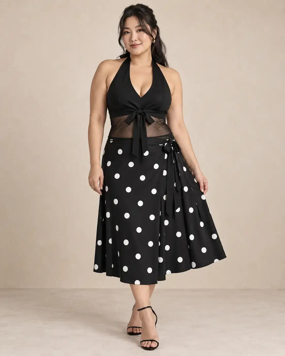Conjunto Cashia Livorno negro en modelo talla L, top halter con escote en V, lazada frontal y cintura transparente, combinado con falda midi de lunares blancos.