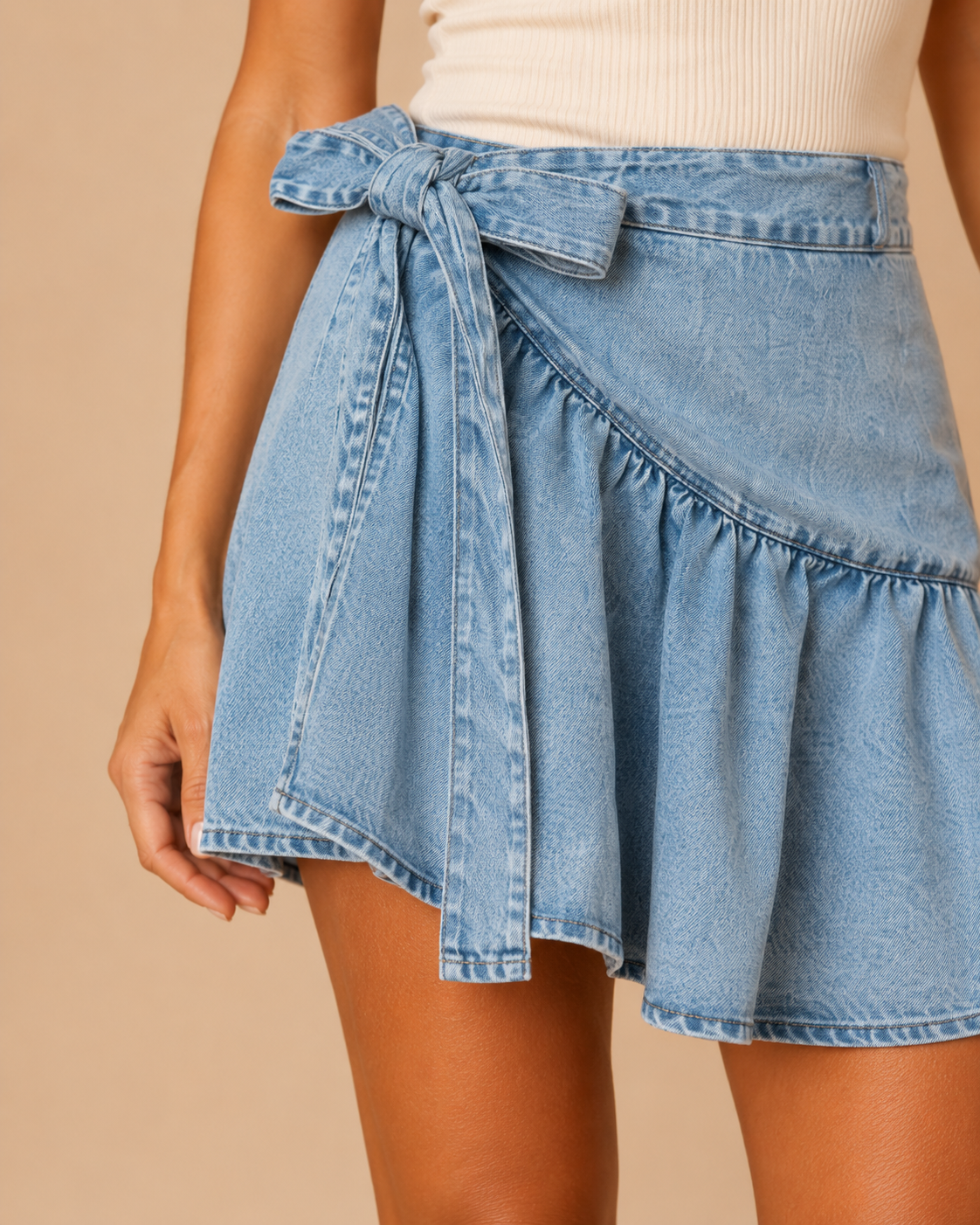 Detalle del lazo lateral de la Falda Cashia Denim Lazo azul con tejido denim y volante inferior.