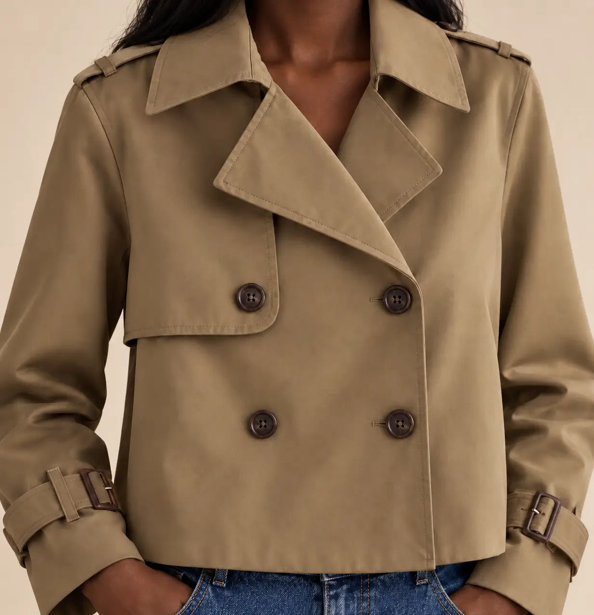 Detalle del cierre cruzado con cuatro botones marrones de la gabardina Cashia Bruma beige.