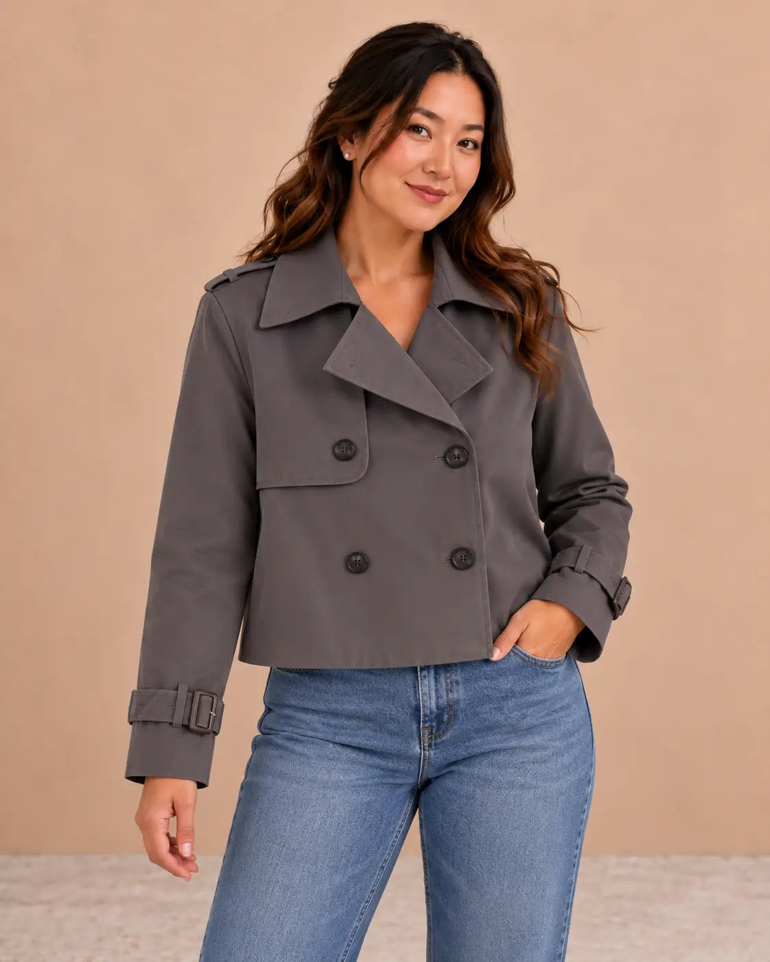 Medio plano superior de la gabardina Cashia Bruma gris, talla L, con vaqueros.