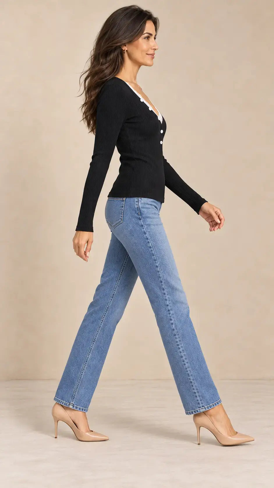 Mujer caminando con jersey de mujer con encaje y botones, jeans y tacones, resaltando el estilo sofisticado.