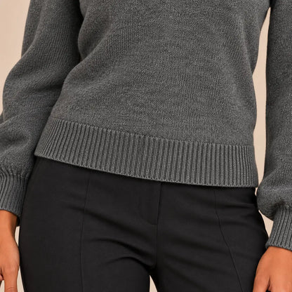 Primer plano sobre modelo del bajo de canalé del jersey Cashia Arolla gris, combinado con pantalón negro de vestir.
