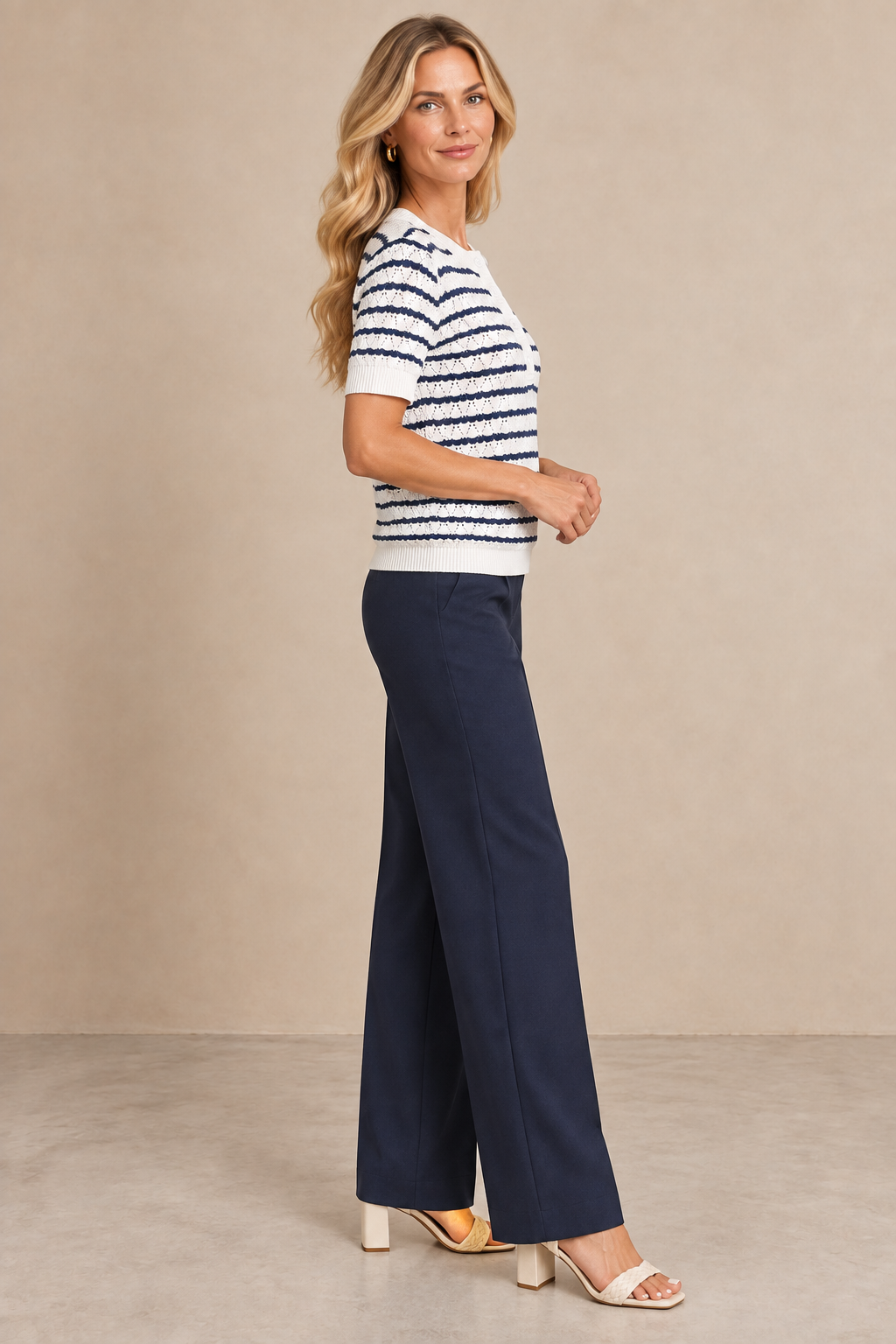 Jersey de punto Cashia Fresno en modelo rubia, vista lateral de perfil con pantalón azul marino.